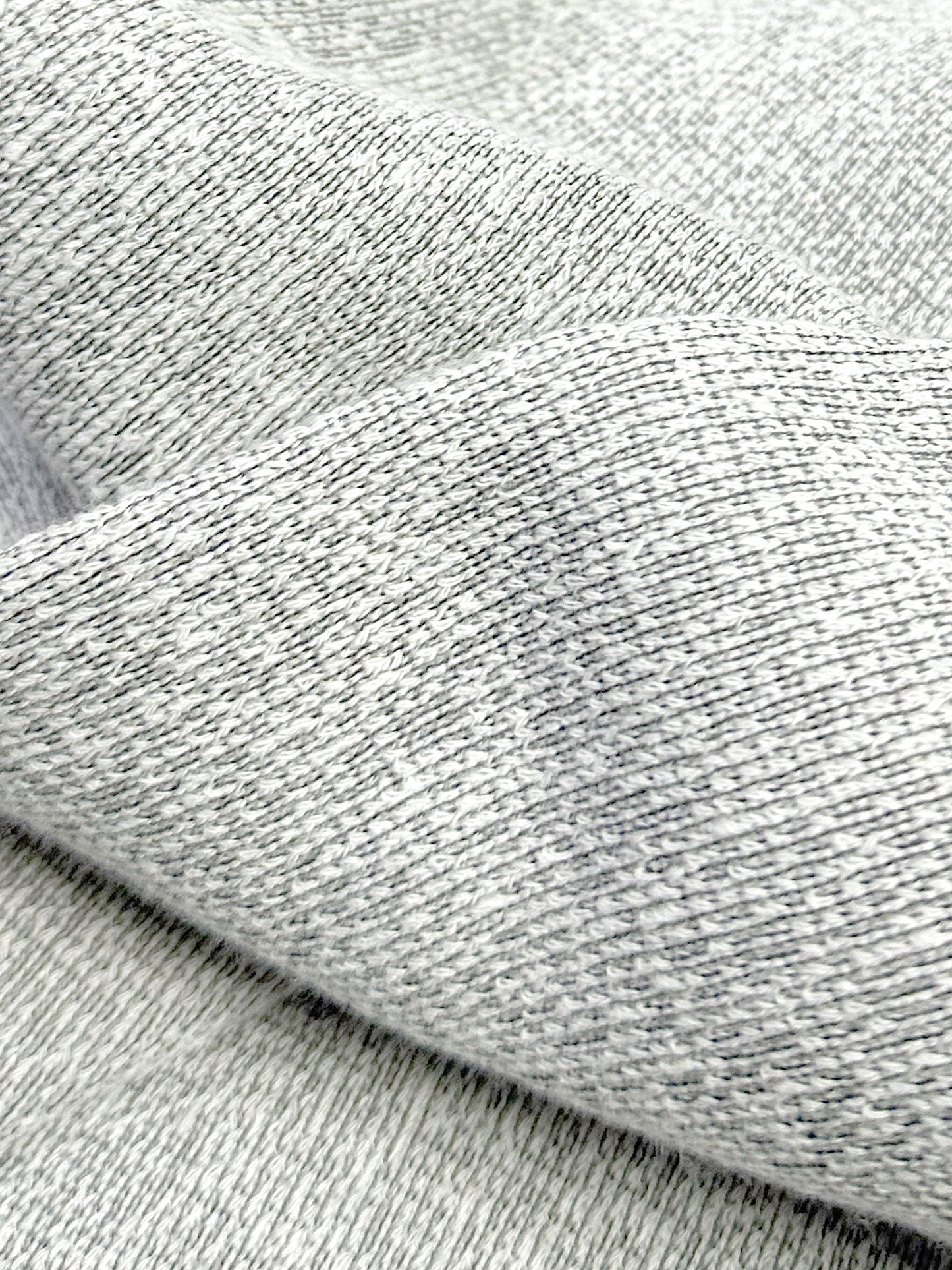 Close-up of mix stone black and white ultra soft plush knit textured fabric with a folded pattern
